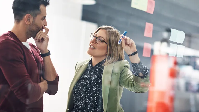 Colleagues discussing business plans at a whiteboard
